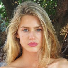 Blonde woman with blue eyes and pink lips outdoors