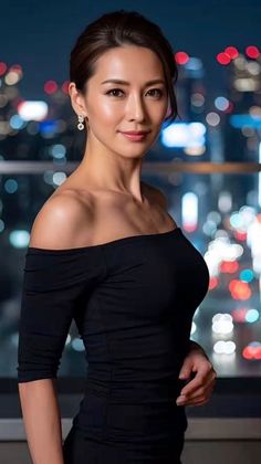 Woman in a black off-shoulder dress with a blurred city night background