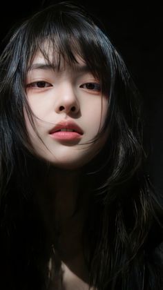 Woman with black hair and bangs in a dramatic close-up portrait