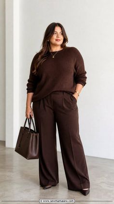 Woman in a brown sweater and wide-leg pants holding a brown handbag