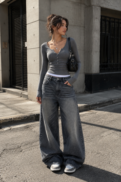 Woman in a gray long sleeve top and baggy jeans on a street
