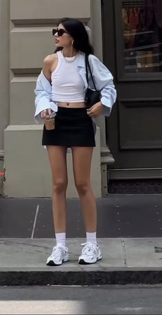 Woman in a black mini skirt and white crop top on a street