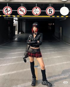 Woman with red hair in a leather jacket and plaid skirt in an urban setting