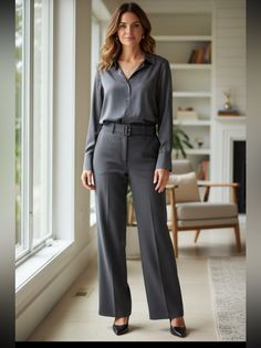 Woman in a gray pantsuit standing in a bright indoor setting