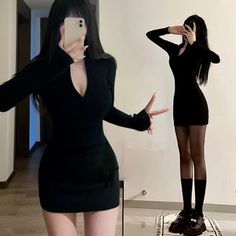 Woman in a black dress taking a mirror selfie, showing cleavage