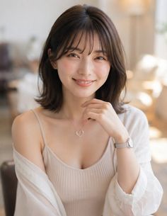Woman with short hair and a heart necklace smiling indoors