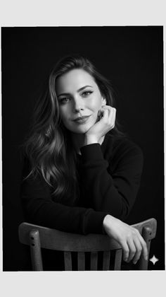 Woman with long hair in a black and white portrait, resting her chin on her hand