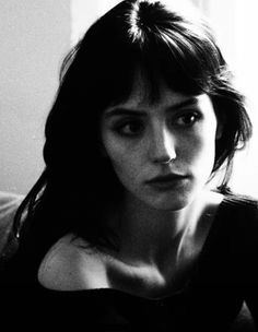 Black and white portrait of a woman with dark hair and exposed shoulder