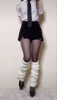 Person in a school uniform with black tights and white leg warmers