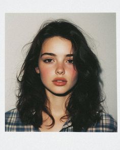 Woman with dark hair and a plaid shirt in a portrait shot