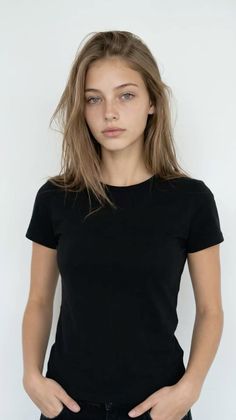 Young woman with long hair and blue eyes wearing a black t-shirt against a white background