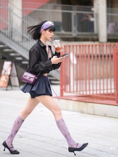 Woman with short hair and a purple headband walking outdoors
