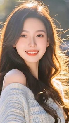 Smiling woman with long hair and an off-shoulder sweater in golden hour light