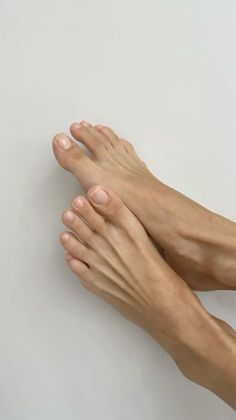 Two bare feet with light pink nail polish on a clean white background
