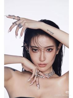 Woman with long black hair and freckles wearing silver jewelry and long nails