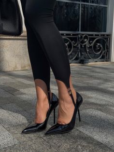 Person wearing black leggings and high heels on a paved street