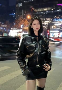 Woman in a black leather jacket and mini skirt on a city street at night