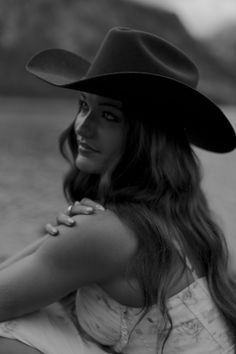 Woman in a cowboy hat with long hair looking over her shoulder