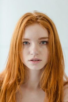 Young woman with long red hair and blue eyes looking directly at the camera