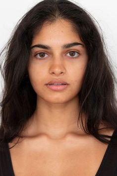 Woman with long dark hair and brown eyes against a white background