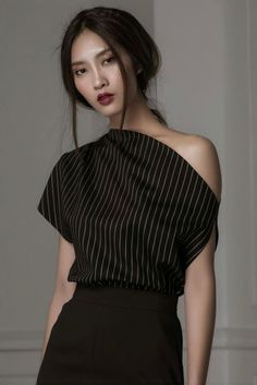 Woman in a black and white striped off-shoulder top with dark lipstick
