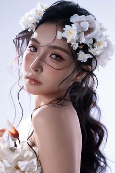 Woman with a white flower crown and bare shoulders looking at the camera