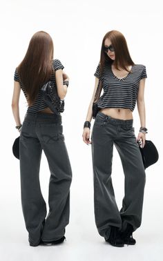 Woman in a striped crop top and wide leg jeans with a belly button piercing