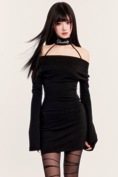 Woman with long black hair wearing a black off-shoulder dress and patterned tights