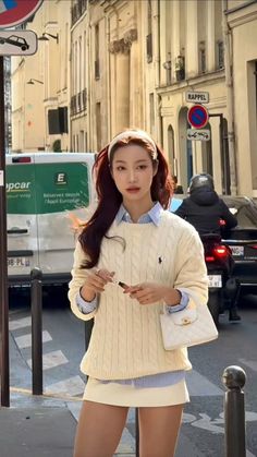 Woman in a sweater and mini skirt on a city street during the day