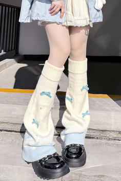 Person wearing leg warmers, platform shoes, and a light blue jacket outdoors