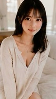 Woman with long black hair wearing a long sleeve shirt with cleavage