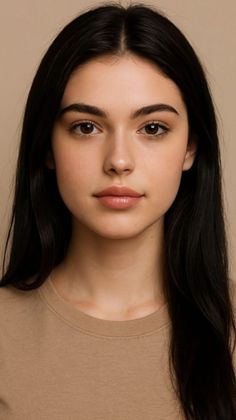 Woman with long black hair and natural makeup wearing a tan t-shirt