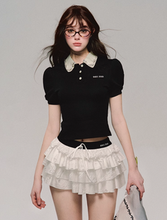 Woman with long hair and glasses wearing a black top and white ruffle skirt