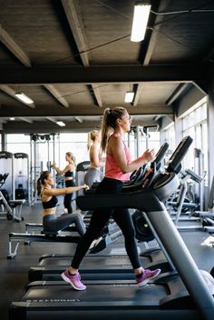 Multiple women exercising on treadmills and rowing machines in a gym