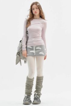 Woman with long hair wearing a pink top, mini skirt, and leg warmers