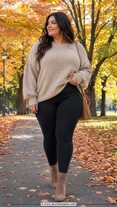 Woman in a sweater and black leggings walking on a path with autumn leaves