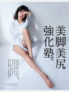 Woman in a white shirt sitting on a white floor with exposed legs