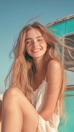 Smiling woman with long blonde hair and freckles in a white dress outdoors