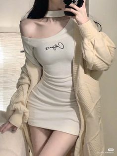 Woman in a tight white dress and long cardigan with one shoulder exposed