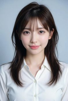Woman with long brown hair and bangs wearing a white collared shirt