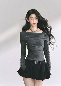 Woman with long black hair wearing an off-shoulder top and black skirt