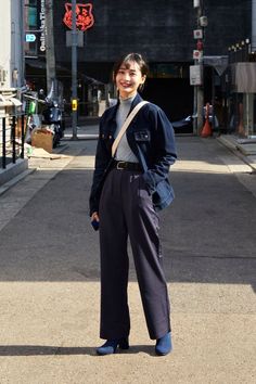 Woman in a denim jacket and wide leg pants standing on a street
