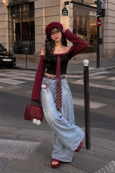Woman in a beret and off-shoulder top with wide-leg jeans on a city street