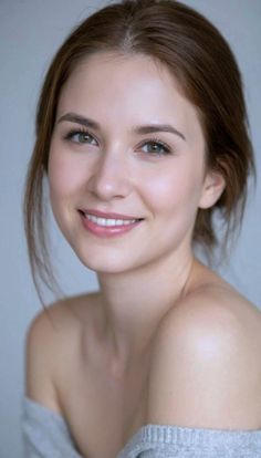 Woman with brown hair and green eyes smiling with bare shoulders