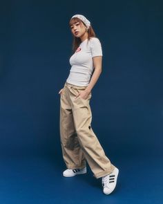 Woman in a white t-shirt and khaki pants with a bandana on a blue background