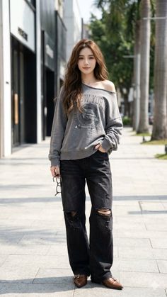 Woman with long hair wearing an off-shoulder top and ripped jeans on a street