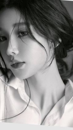 Close up monochrome portrait of a woman with dark hair and a white shirt