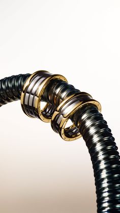 Two gold and silver rings intertwined on a metal coil
