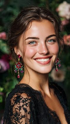 Woman with blue eyes and colorful earrings wearing a black lace top