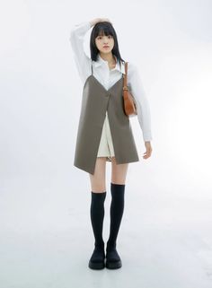 Woman with long black hair wearing a white shirt and sleeveless top with knee-high socks